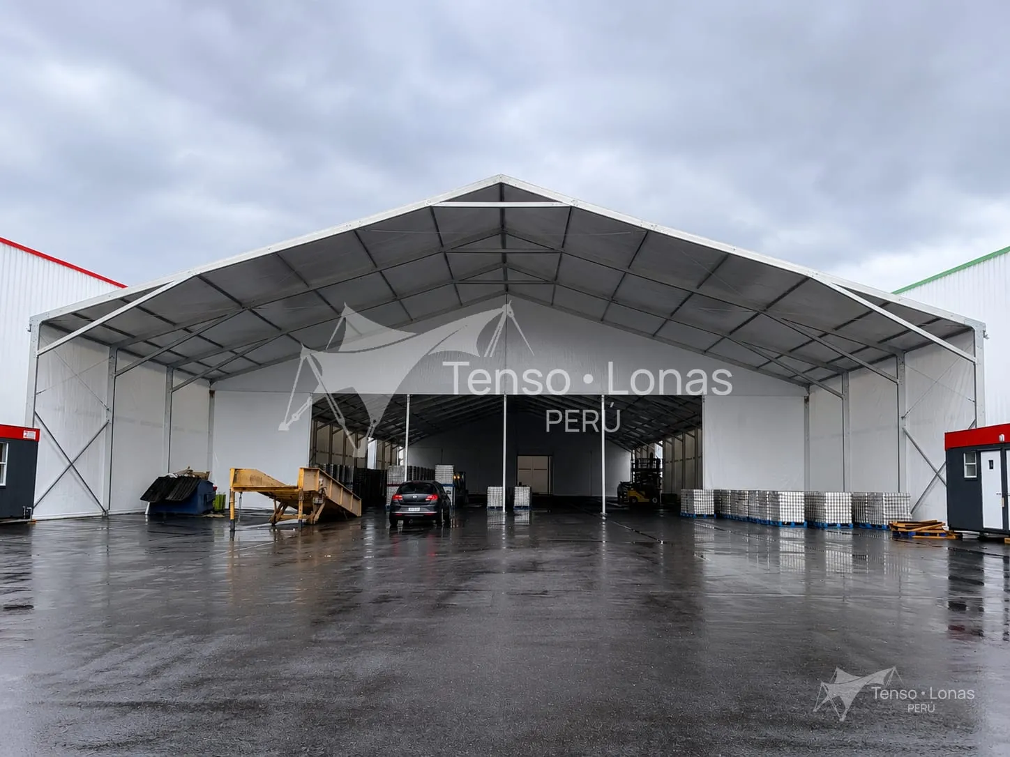 Almacén tipo hangar con cobertura de lona y frente abierto para maniobra