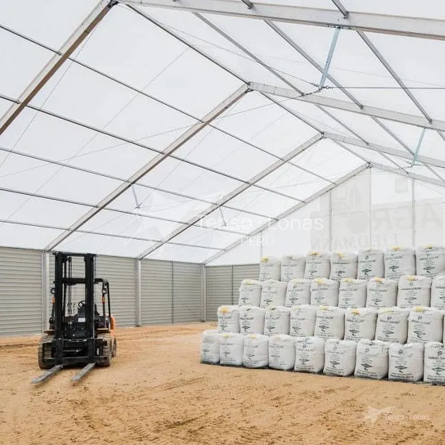 Cobertizo industrial con big bags acopiados y un montacargas en operación