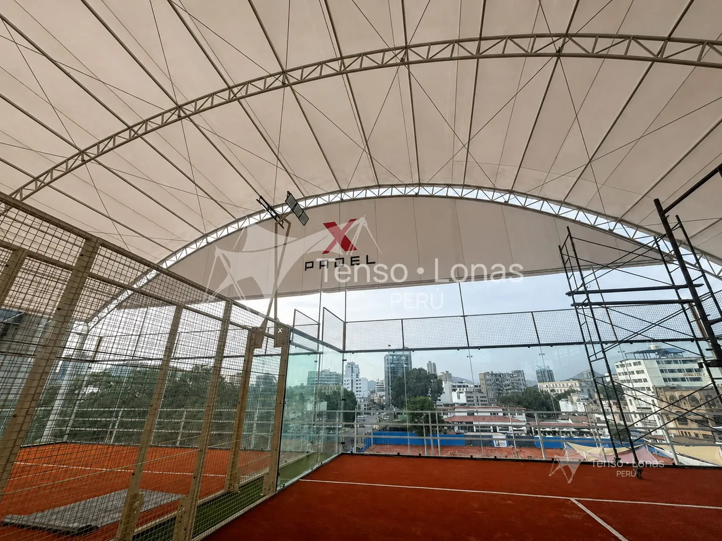 Cancha de pádel cubierta con una membrana tensada de lona PVC blanca sobre estructura metálica curva