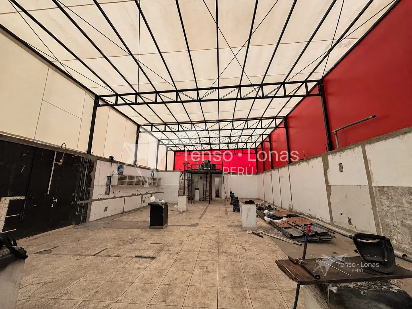 Cobertura tensada de gran superficie sobre el interior de una nave industrial en obra