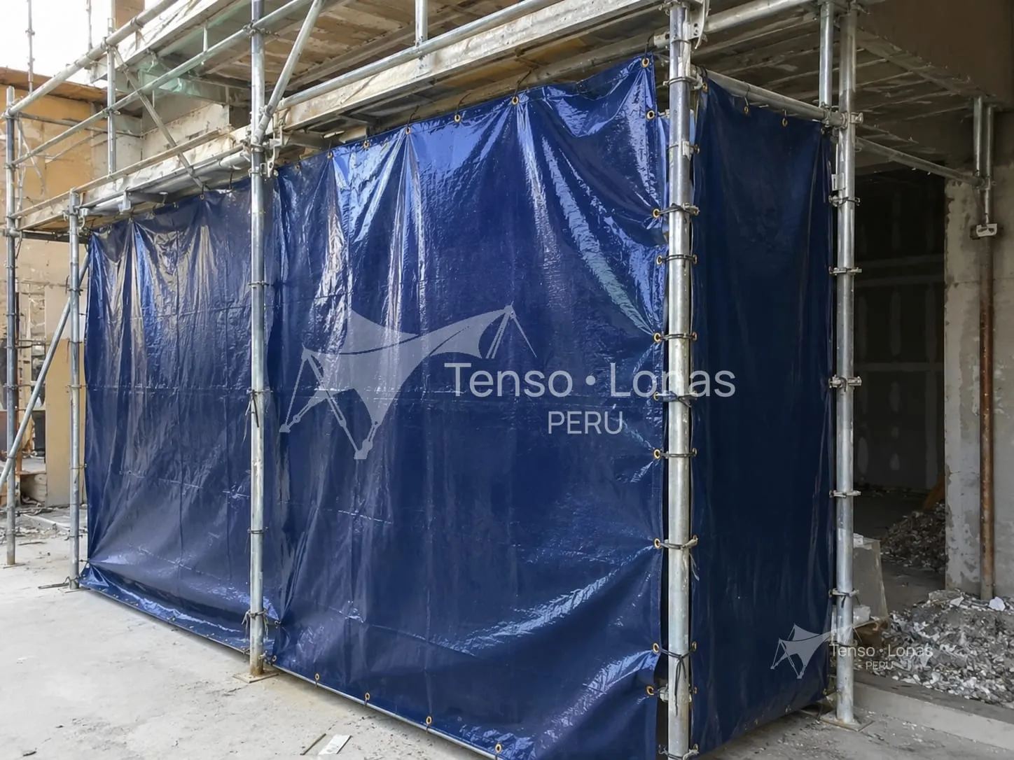 Andamio de obra cerrado con mantas de tarflex azules para contener polvo y residuos