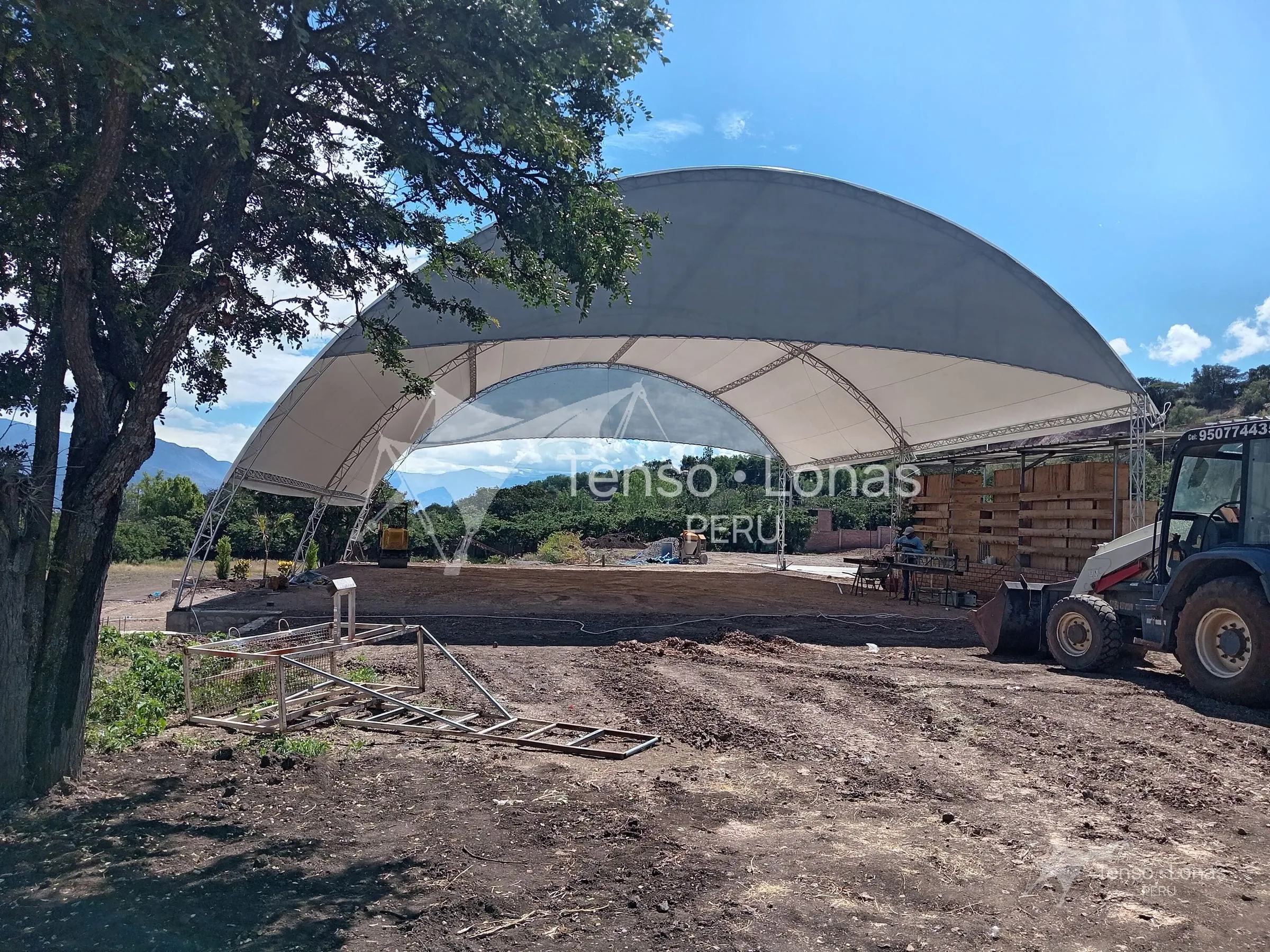 Vista lateral de la cobertura parabólica de lona PVC con los arcos metálicos tensados