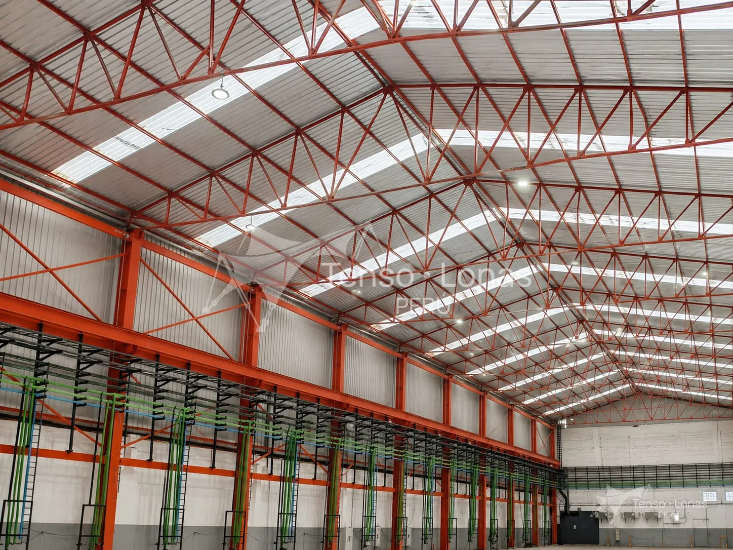 Tijerales metálicos cubriendo la luz completa de una nave, vistos desde el interior