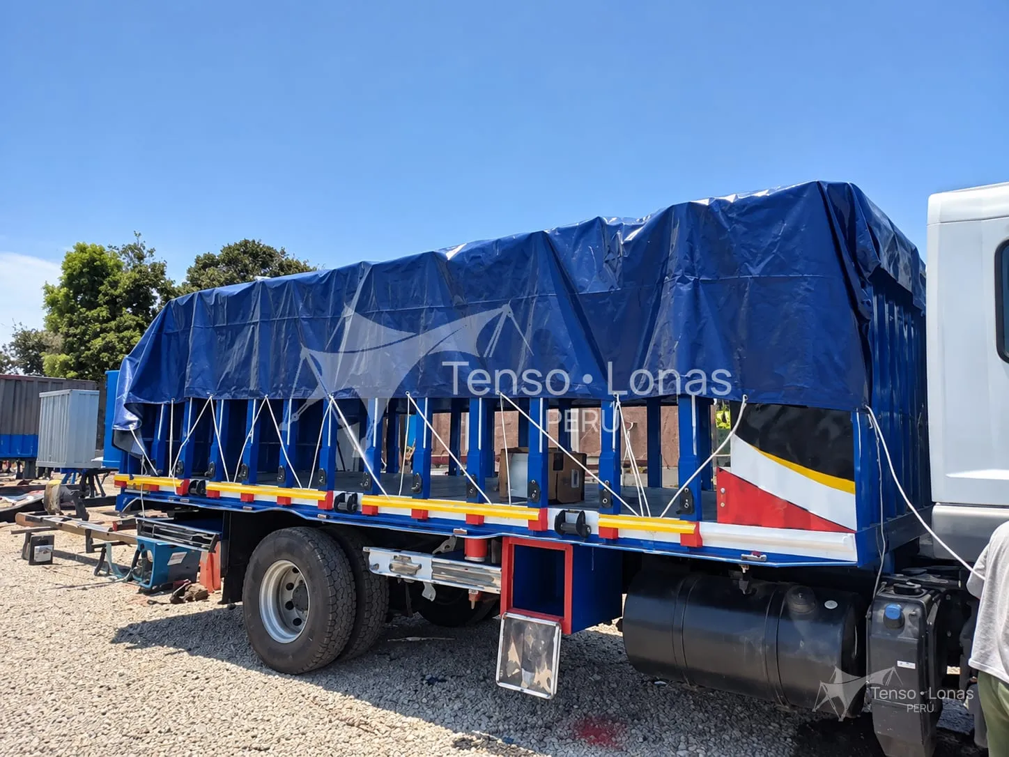 Toldera cubriendo estructuras metálicas cargadas en una plataforma