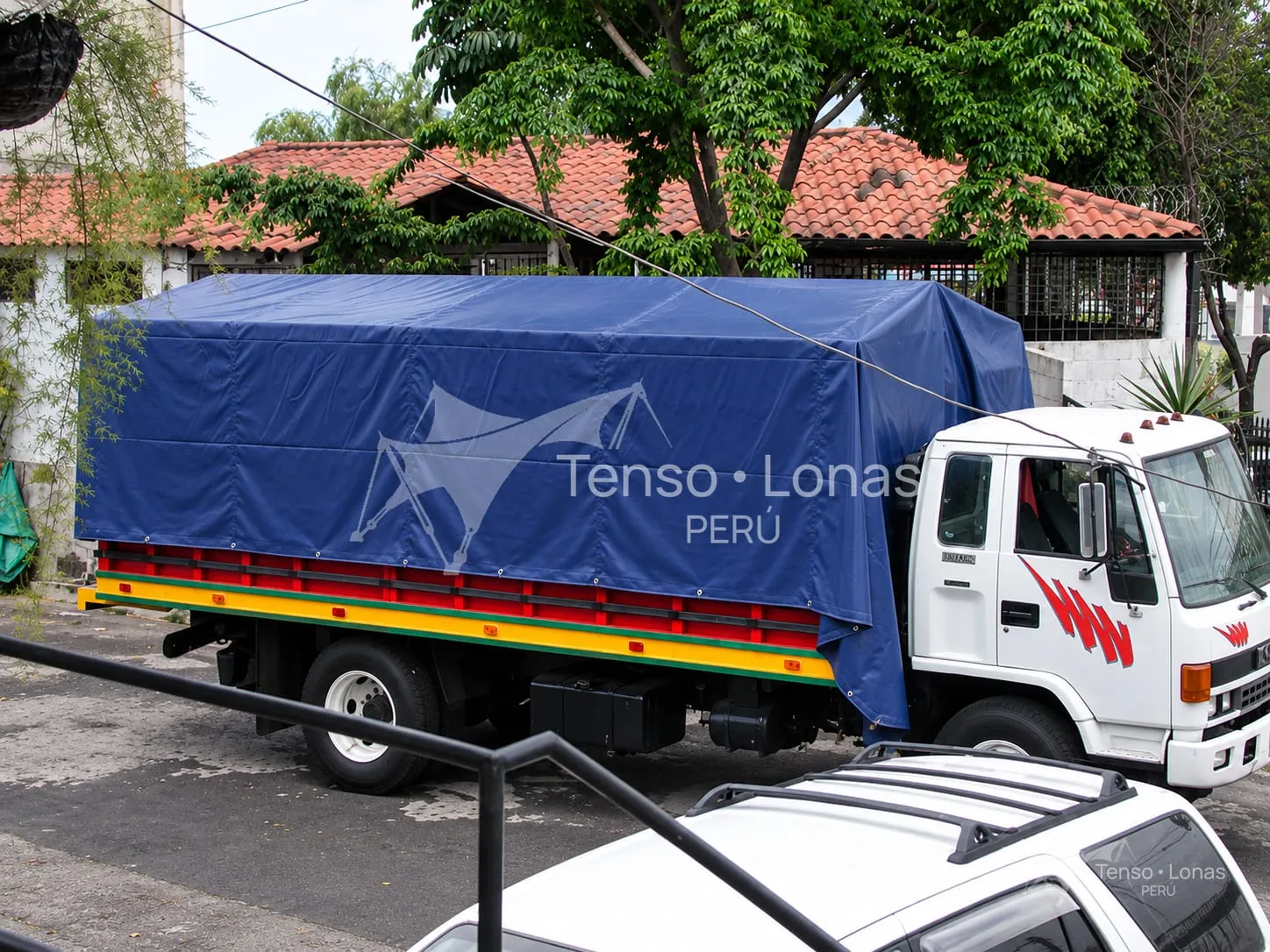 Camión con toldera azul montada sobre arcos tubulares desmontables