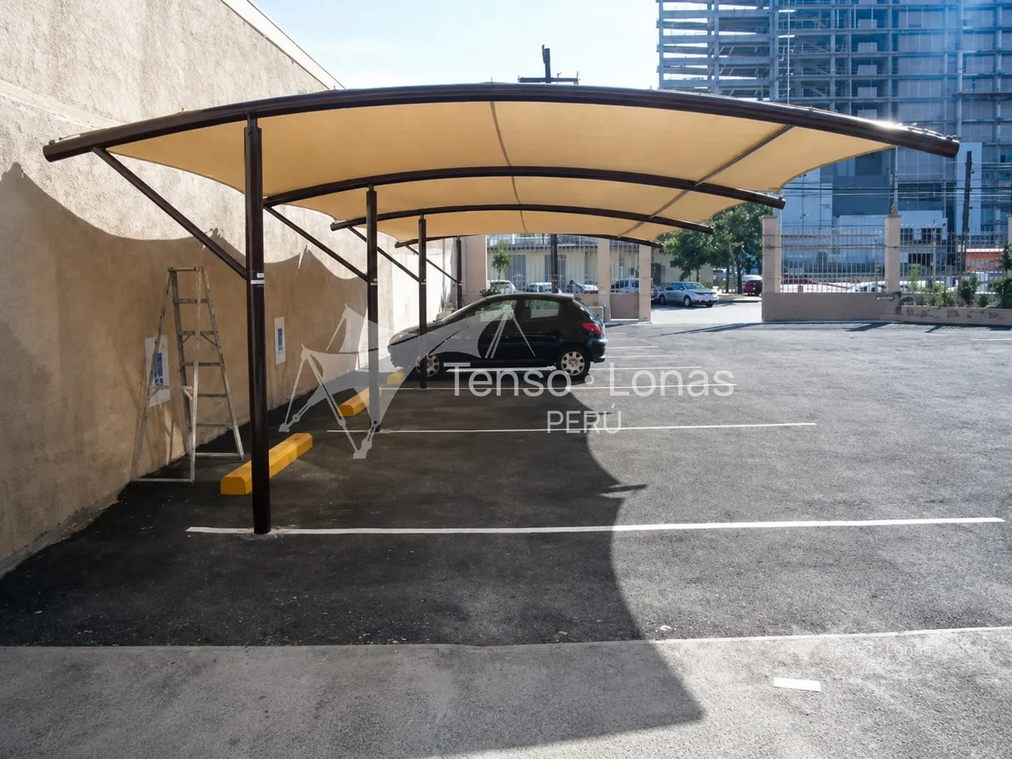 Cobertura curva en voladizo sobre las plazas de un estacionamiento