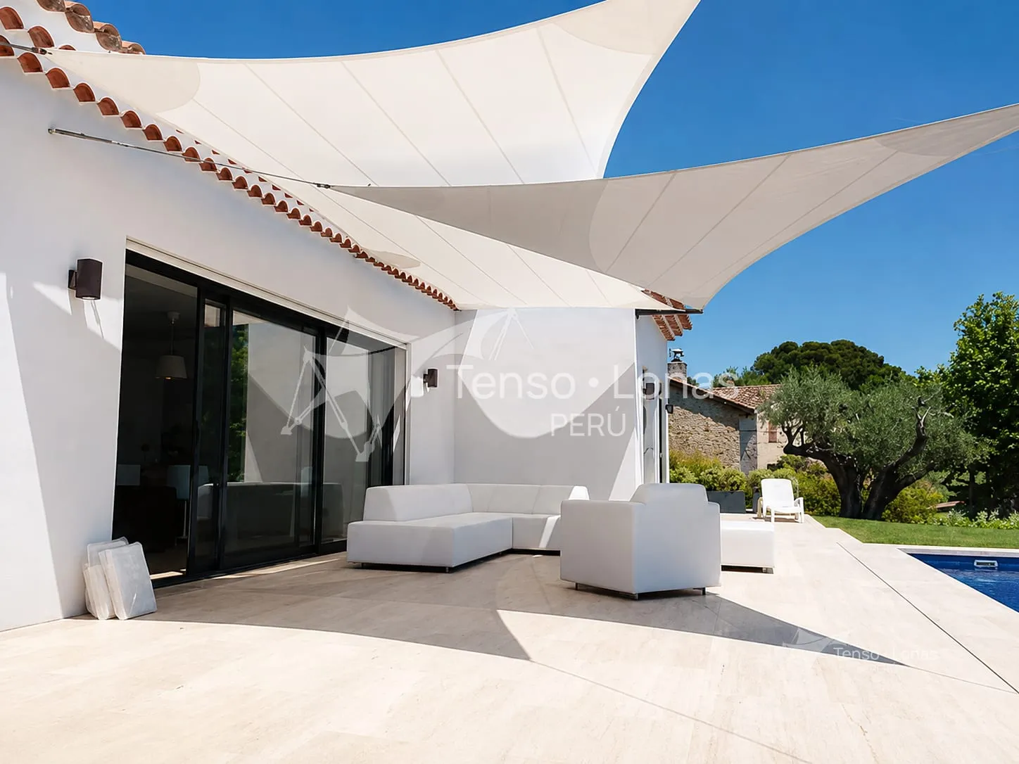 Toldos tipo vela blancos tensados sobre la terraza y la piscina de una vivienda